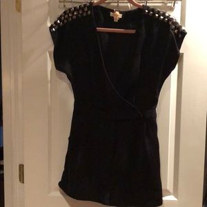 Black romper with accessorized shoulders.